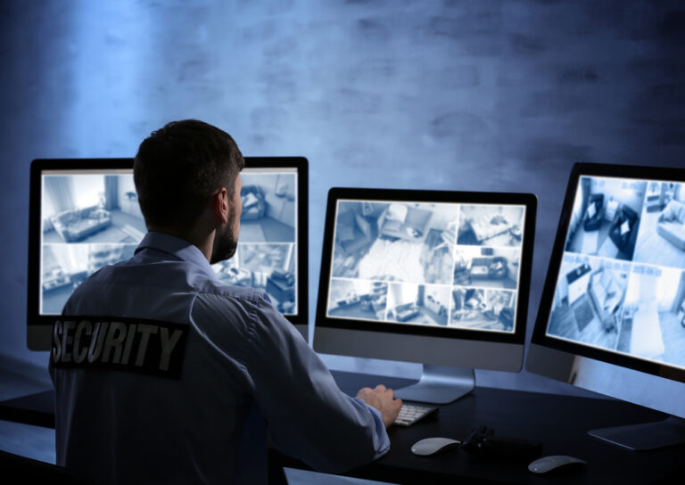 Security guard monitoring surveillance cameras